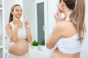 woman applying cream during pregnancy